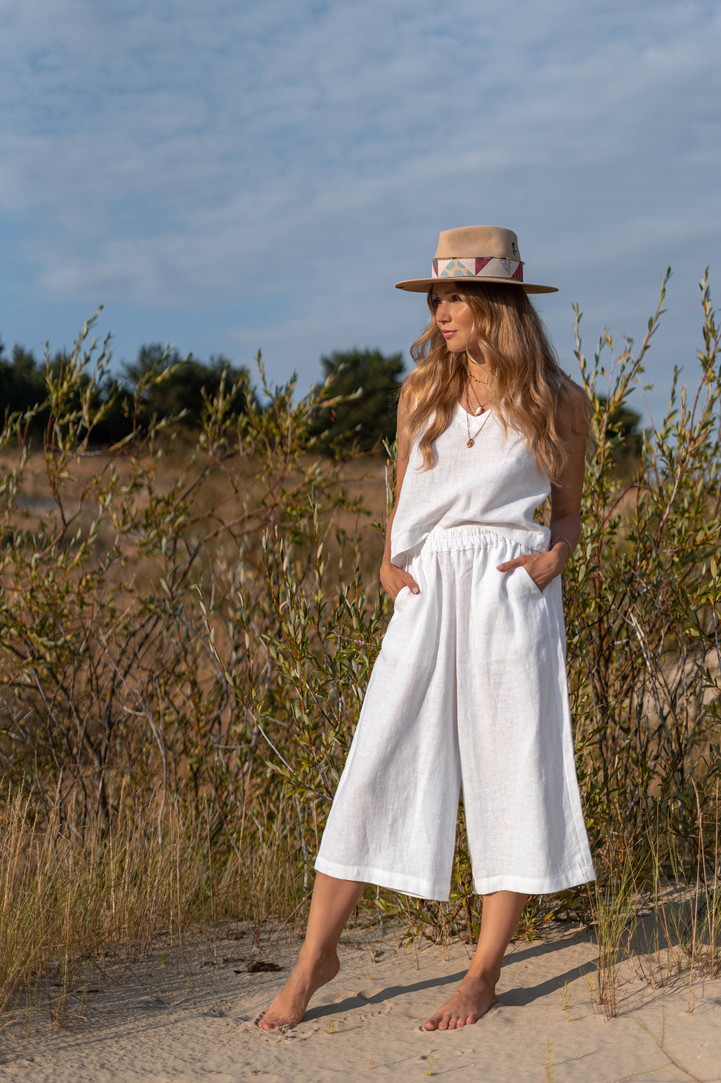 White linen pants walking outdoors showing wide-leg shape and comfort, handmade linen pants slow fashion