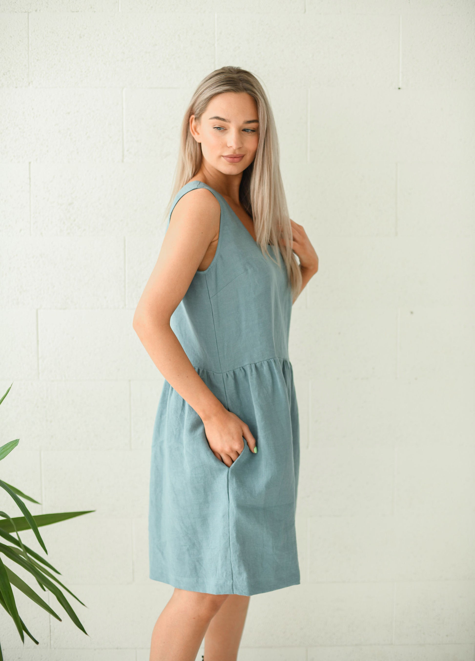 Dusty turquoise linen dress half profile view showing sleeveless cut, handmade linen dress slow fashion