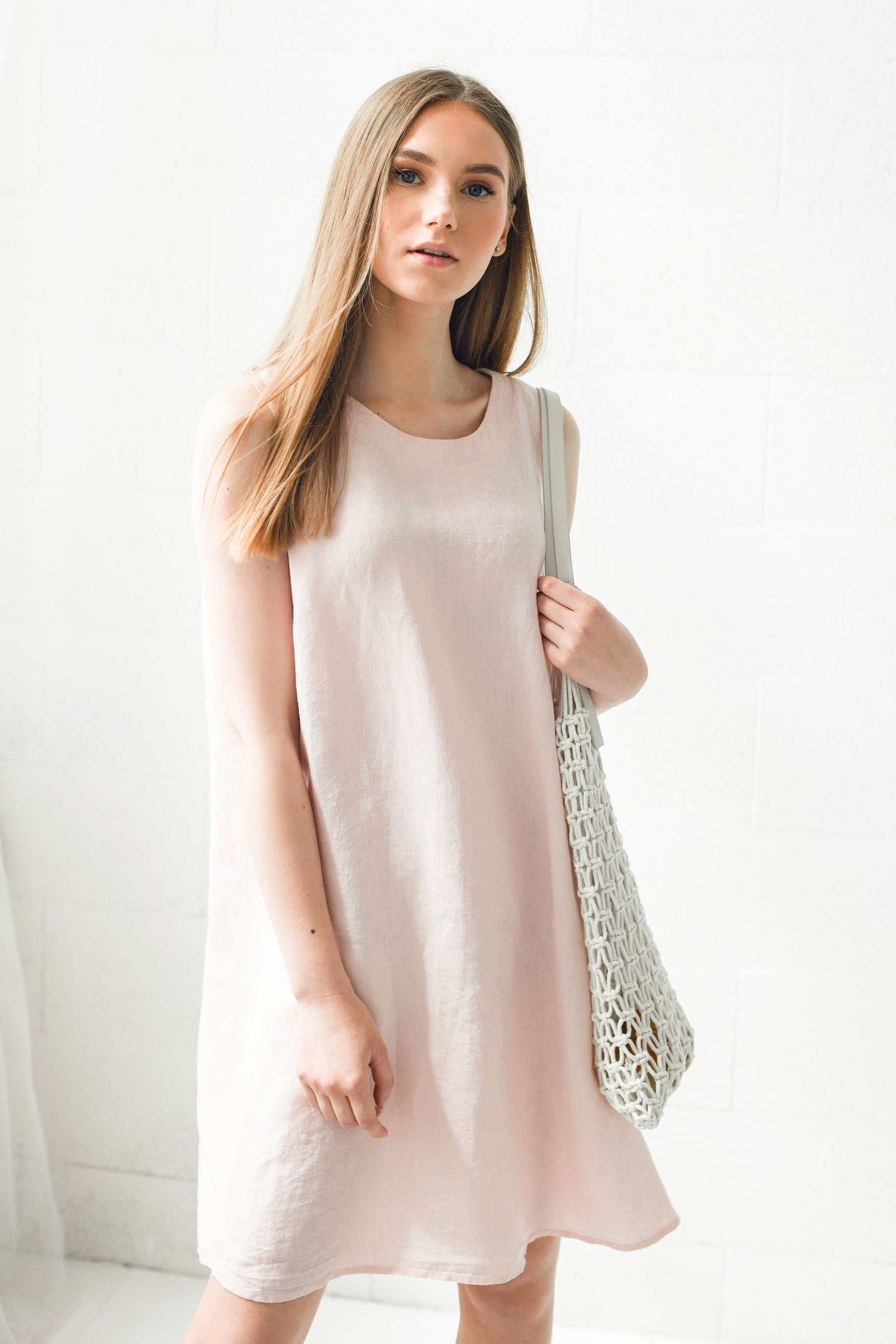 Dusty rose linen dress in natural light showing soft drape and movement, handmade linen dress slow fashion