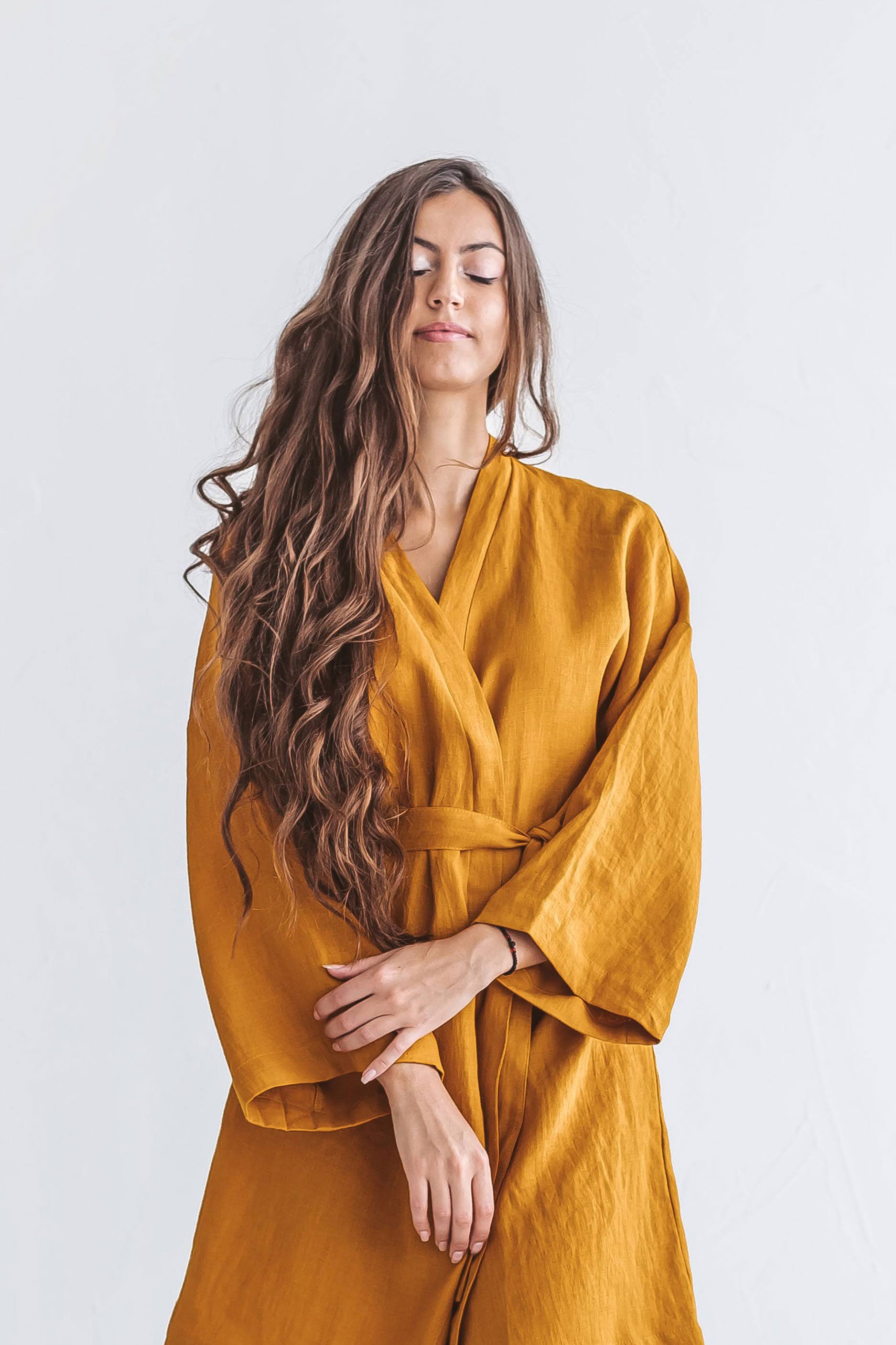 Mustard linen robe closeup showing soft drape and fabric detail, handmade linen robe slow fashion