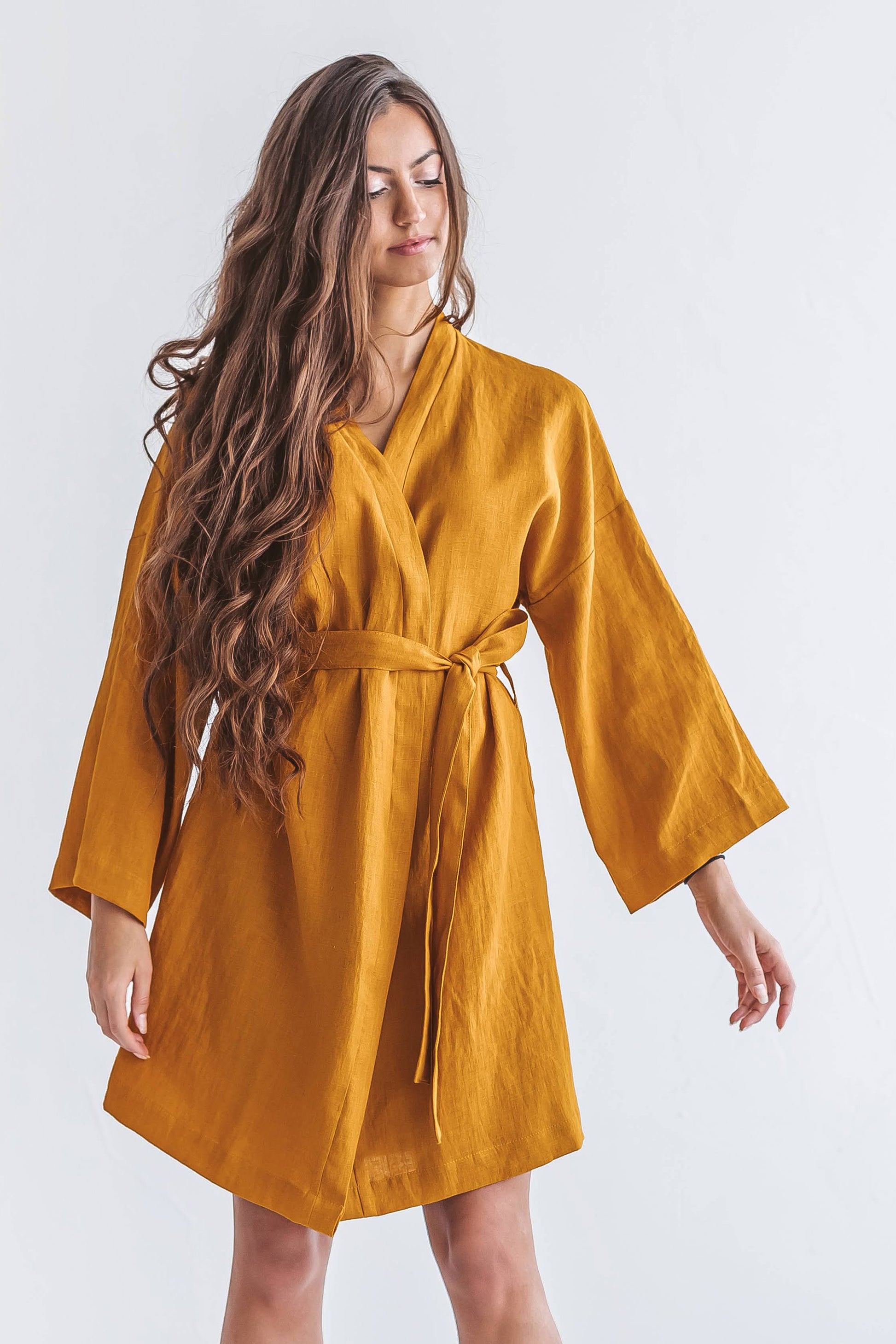Mustard linen robe relaxed pose showing kimono-style silhouette, handmade linen robe slow fashion