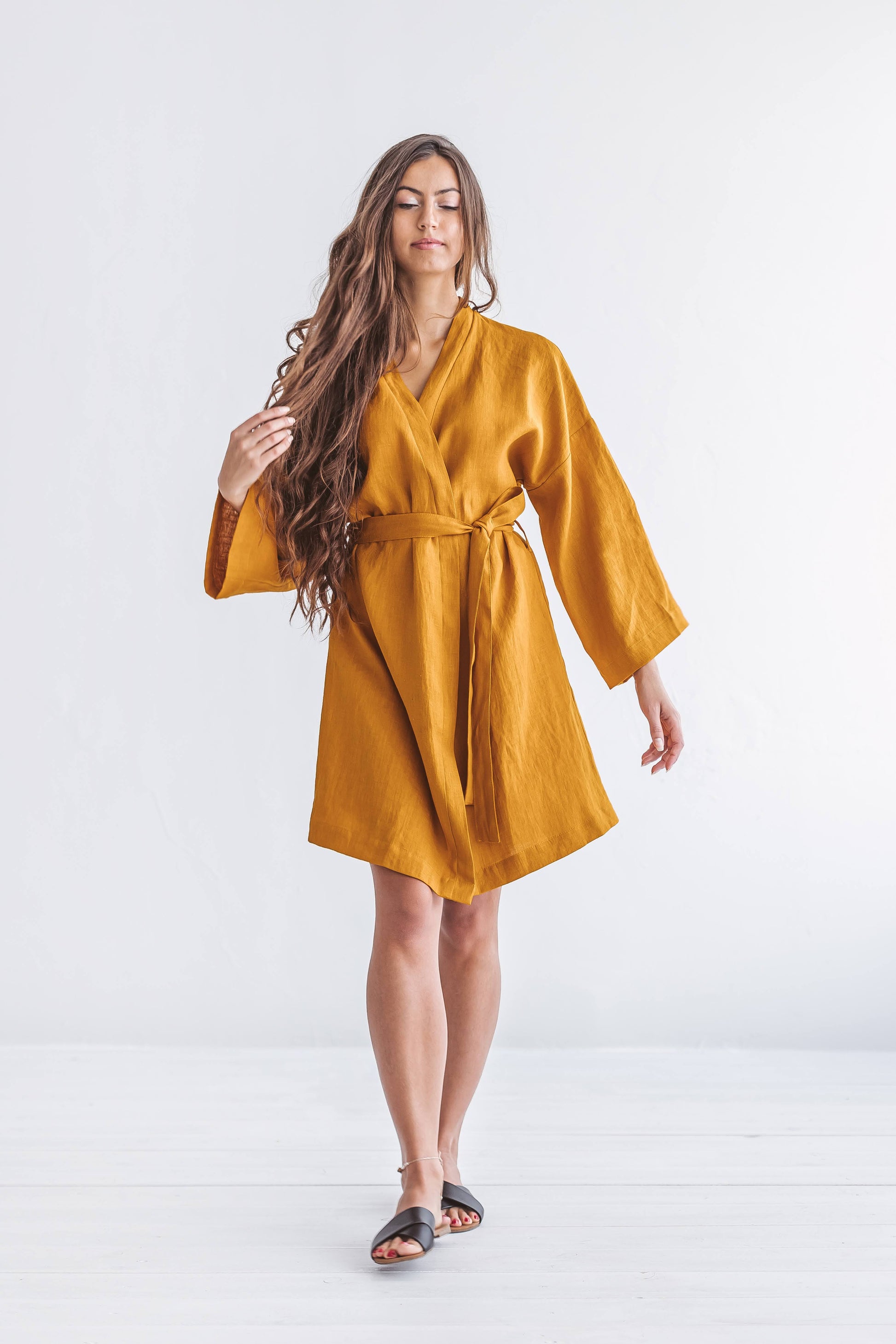 Mustard linen robe turning pose showing relaxed fit and movement, handmade linen robe slow fashion