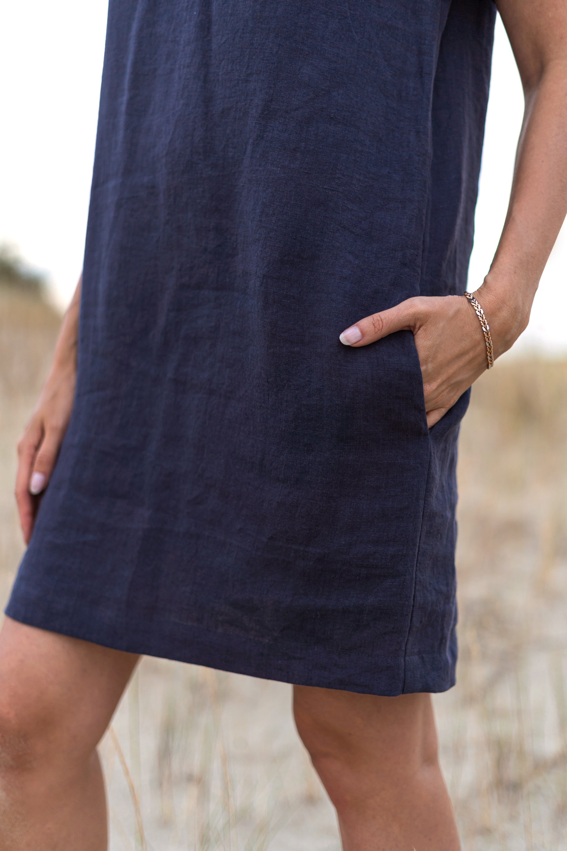 Graphite grey linen dress outdoor pose showing relaxed mini length, handmade linen dress slow fashion