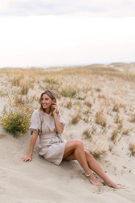 Woman sitting on sand dunes in a natural setting
